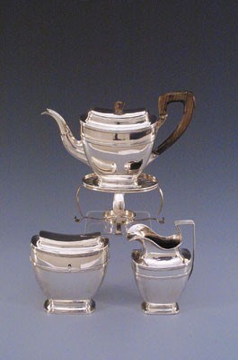 Lot 1509 - Drie-delig zilveren theeservies op comfoor.