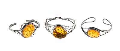 Lot 576 - Three Arts and Crafts Style Silver and Amber Bracelets