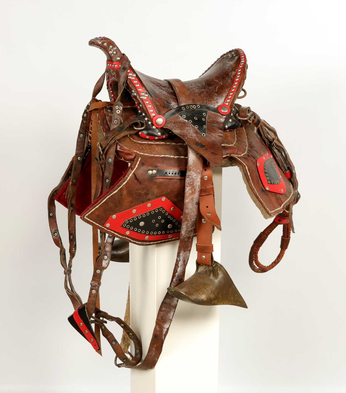 Lot 528 - Antique leather saddle, with brass stirrups and decorated with studs